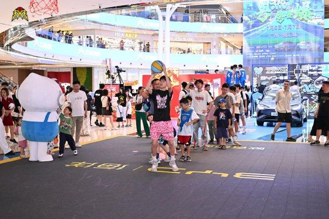 球迷在比亚迪汽车海洋网活动区参加投篮挑战活动